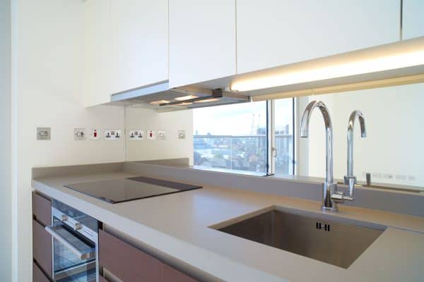 Interior of a newly furnished modern kitchen with flourescent lights and white walls, 9 Ideas To Replace The Fluorescent Lights In Your Kitchen [With Pictures]